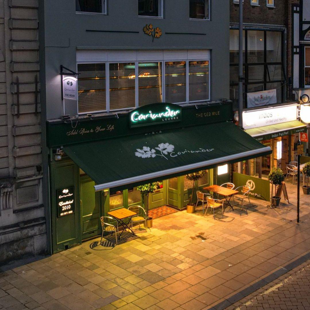 Coriander Lounges restaurant lighting up high street on a dark night