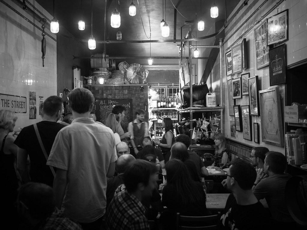 Black and white image of people gathered inside a pub