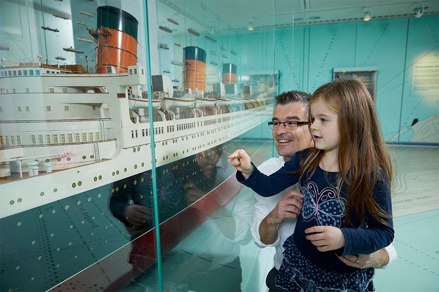 Man and young girl looking at Titanic model in SeaCity Museum