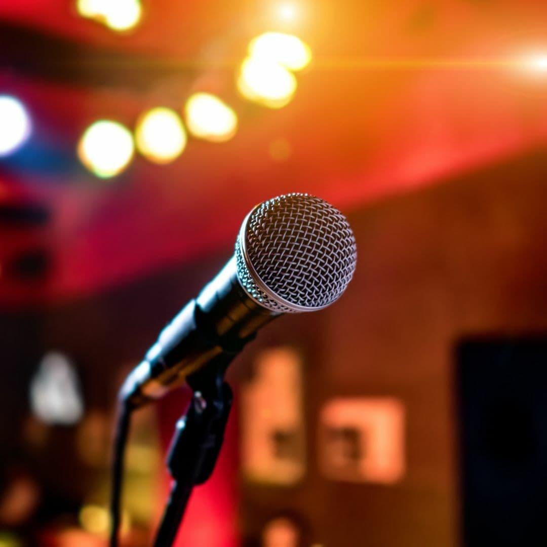 Black mic held in stand on empty stage