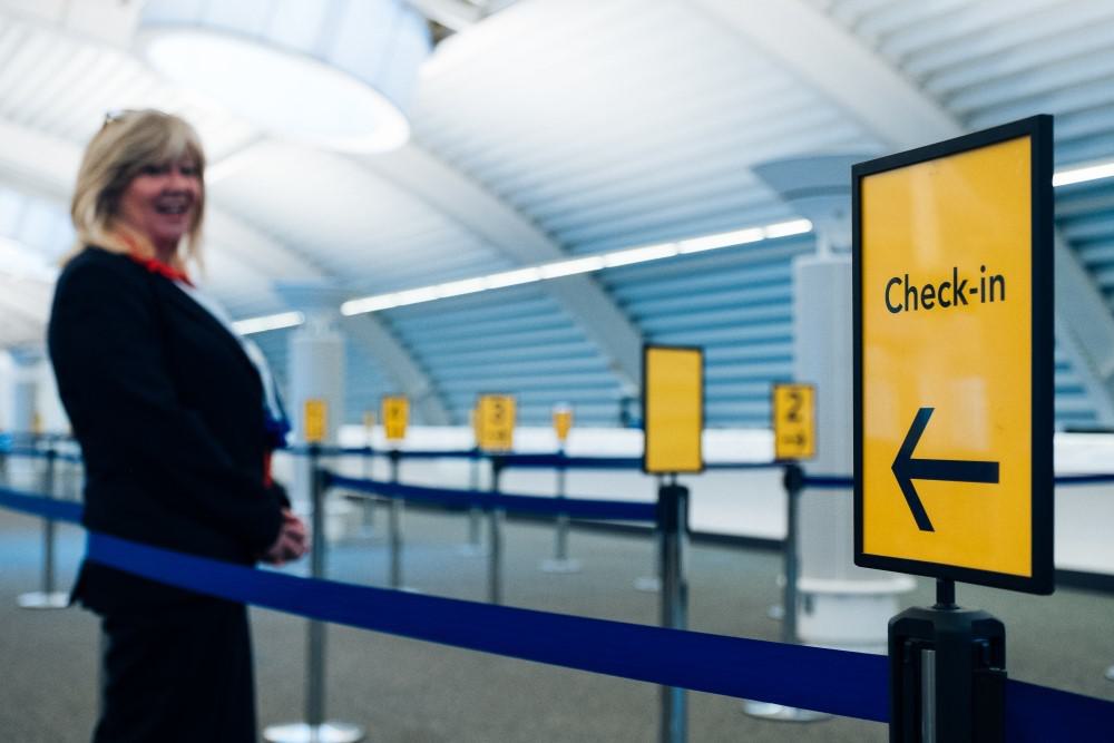 Lady stood by a check-in sign at Southampton cruise terminal