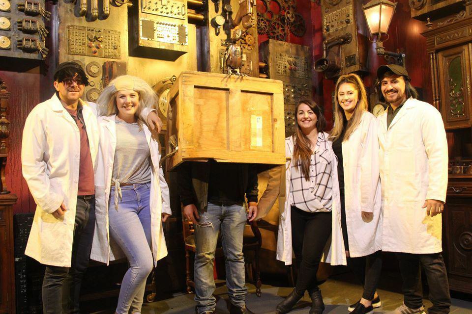 Group of people in white coats with person inside a wooden box